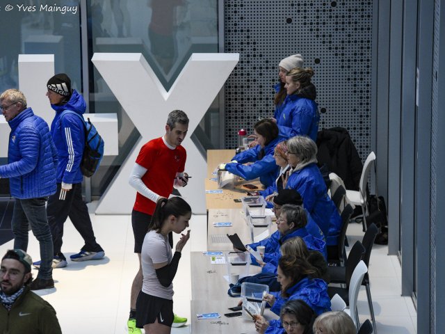 La rangée des bénévoles au retrait des dossards, vue depuis le bout du comptoir.