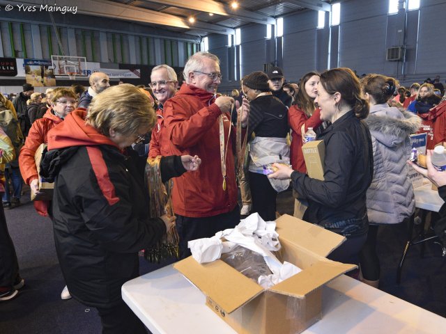 Le hall après l'arrivée : bénévoles et coureurs mêlés autour des cartons de ravitaillement.