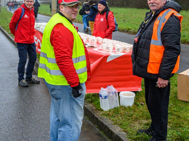 Un poste de ravitaillement sur le parcours, gobelets alignés sur la table, bénévoles en gilet de sécurité.