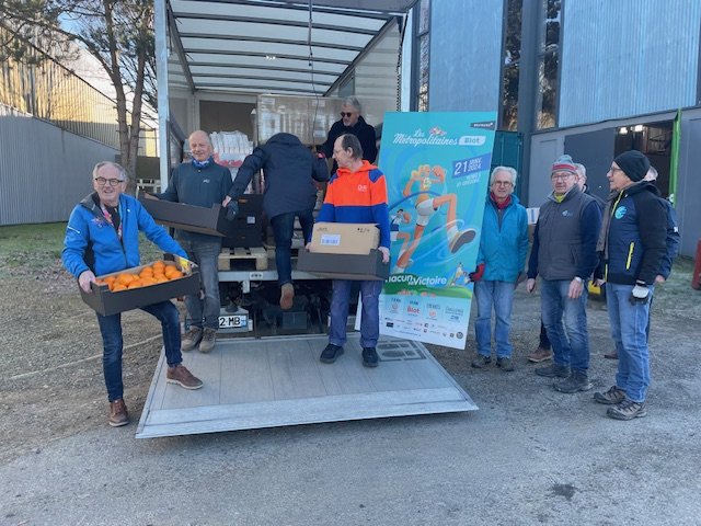 Le déchargement du camion : des bénévoles descendent les cartons d'oranges par le hayon.